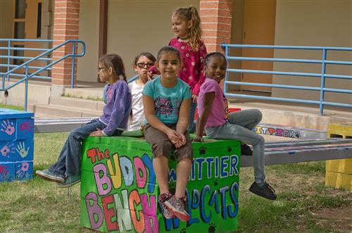 Students sitting on Th Buddy Bench at Whittier School
