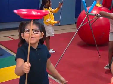 Bethune students balance a spinning plate on a stick, ride a unicycle, & balance atop a giant ball.