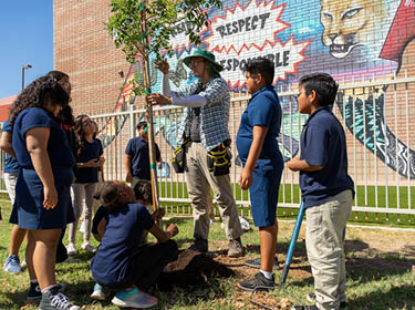 Students work with ASA volunteers to plant trees at Capitol. 