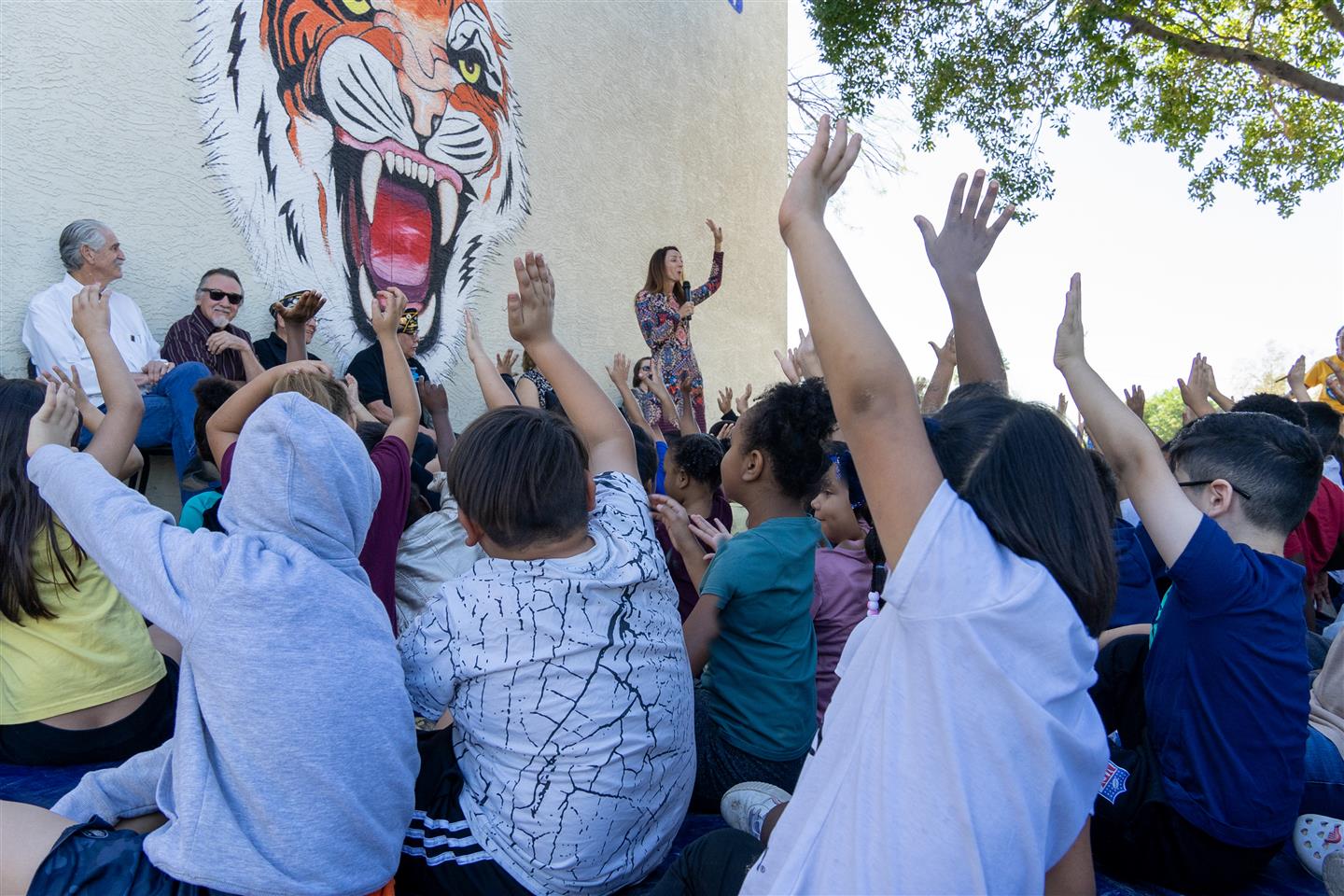 Students raising their hands answering,