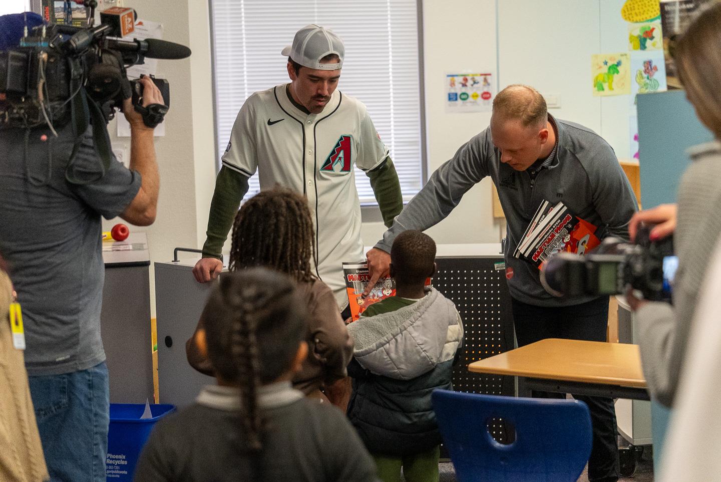 Handing out books to kindergarteners and pointing to an illustration, “Look, that’s him!”