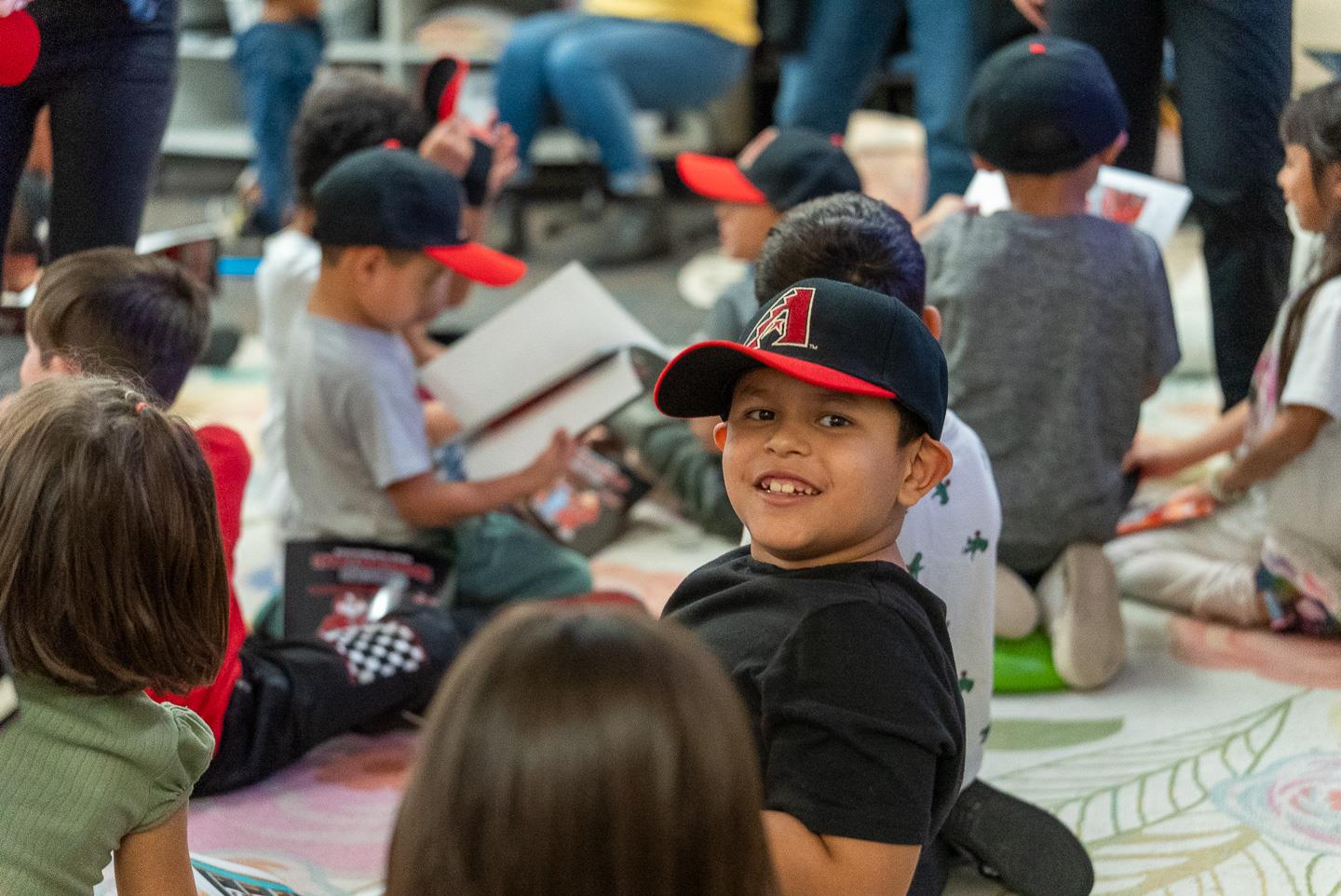 Proudly showing off a new hat and diving into a fresh book.