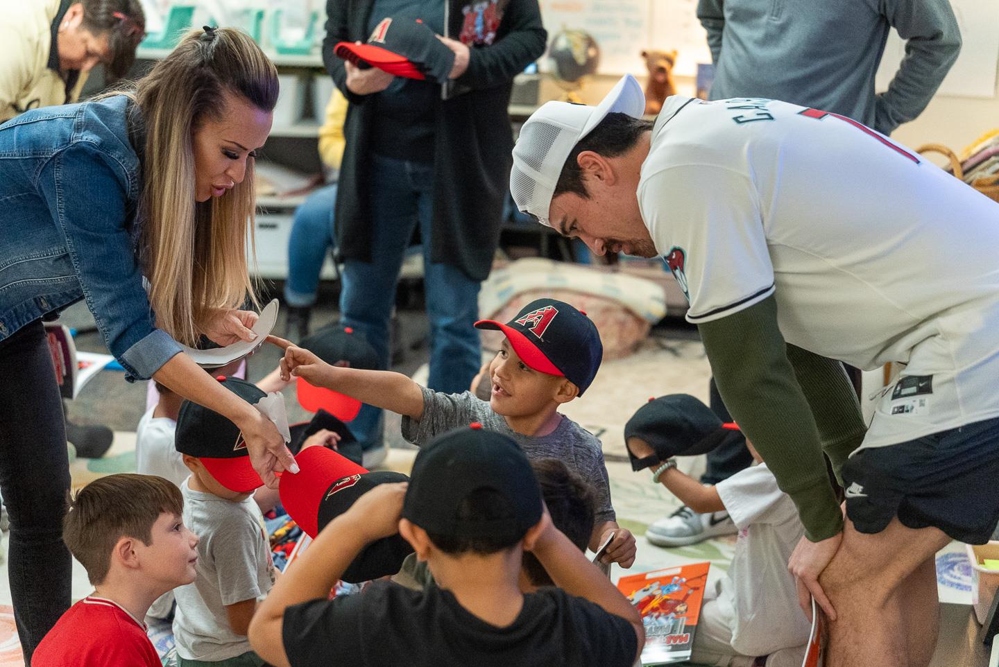 Corbin Carroll and his team spreading smiles as they hand out books and hats.