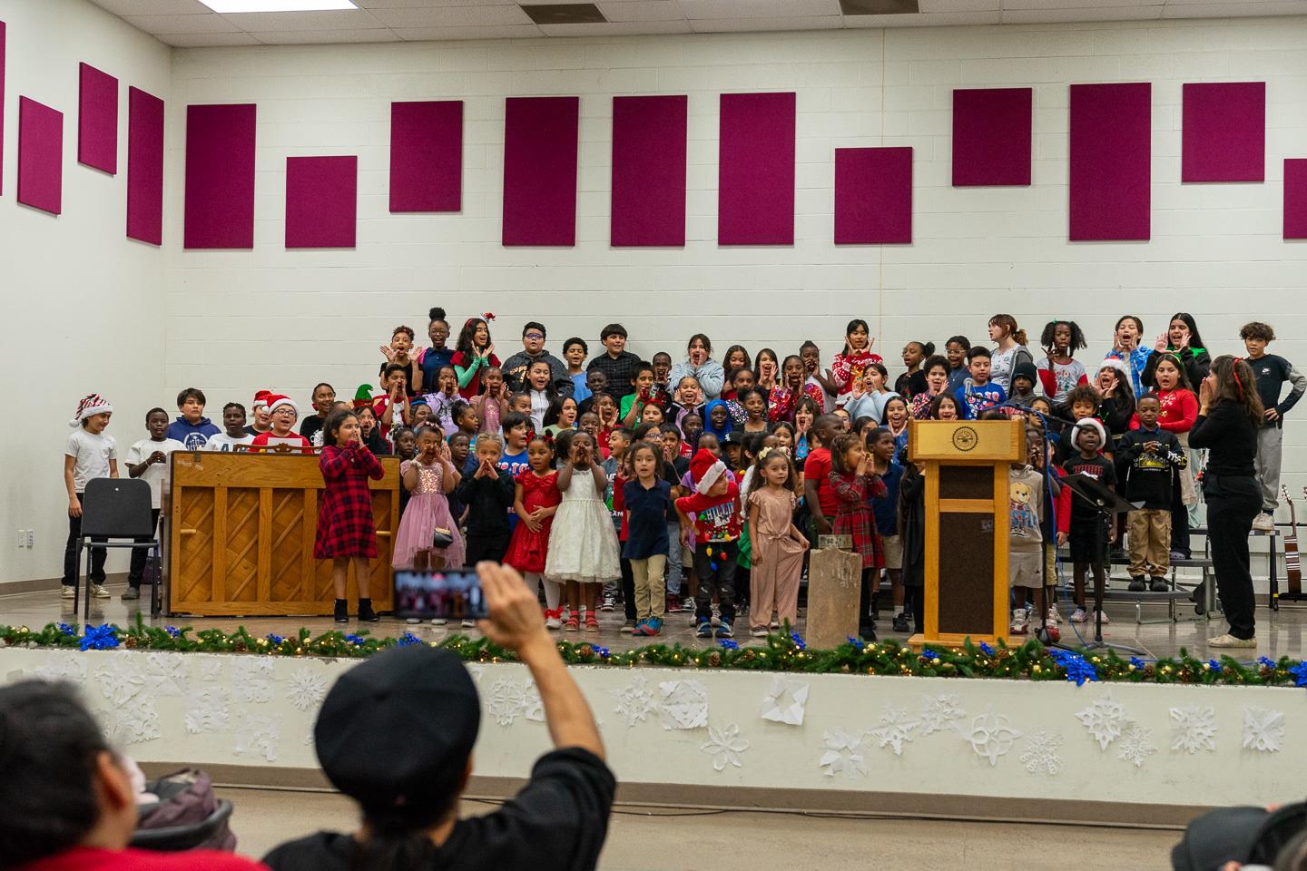 The student choir’s faces lit up as they reached the powerful, energetic crescendo of their song. Parents captured the moment on their smartphones.